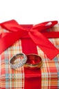 Pair of golden rings with orange rose on the red gift box with r Royalty Free Stock Photo