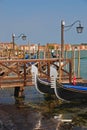 A pair of Gondola Ferro moored at Wooden Pier with a pair of street lamp at Venice