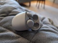 Pair of Google Pixel Buds on a gray couch, surrounded by a neutral-colored room