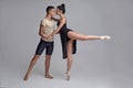 Two athletic modern ballet dancers are posing against a gray studio background. Royalty Free Stock Photo