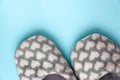 Pair of gray fluffy slippers on blue background. Warm cozy home footwear. Rest at home, relaxation, coziness concept Royalty Free Stock Photo