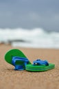 A pair of green and blue flip flops on the beach Royalty Free Stock Photo