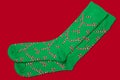 Pair of green socks with santa claus staff template, lie on red background, concept
