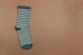 Pair of green striped socks on brown background, flatly, minimal style, top view, copy space. Concept male clothing, housekeeping Royalty Free Stock Photo