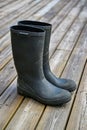 Pair of green wellys standing on wooden decking