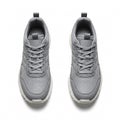 A pair of grey sneakers with white soles, isolated on a white Royalty Free Stock Photo