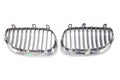 A pair of grille on a white background made of shiny chromed metal is an element of the car body that protects and passes air to
