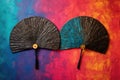 a pair of hand fans crossed on a vibrant, textured backdrop