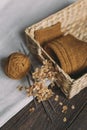 A pair of hand knitted socks in a basket, knitting needles and yarn ball. Background for handmade and slow homelife