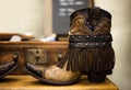 Pair of handmade brown leather cowgirl boots with vintage suitcase in background
