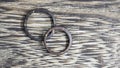 Pair of handmade coconut rings in wooden background. Natural and artisan wedding ring bands. Love and union concept.