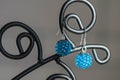 A pair of handmade earrings from beads of turquoise color