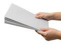 A pair of hands holding a stack of light gray paper sheets against a white background Royalty Free Stock Photo