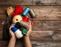 Woman holding clews of threads on wooden background, top view. Space for text Royalty Free Stock Photo