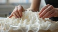 A pair of hands meticulously arranging and smoothing layers of a flexible rubberlike material being printed into a