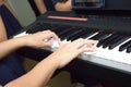 A pair of hands playing a musical keyboard piano organ instrument