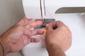 A pair of hands pulling thread on a sewing machine Royalty Free Stock Photo