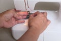 A pair of tailor's hands working on her electric sewing machine Royalty Free Stock Photo