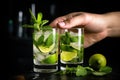 a pair of hands squeezing lime into a mojito cocktail