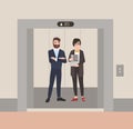 Pair of happy friendly male and female employees or office workers standing in elevator with open doors. Colleagues