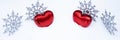 A pair of hearts and snowflakes in the snow in a semicircle. Christmas snowy background with red hearts. Christmas panoramic