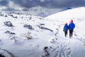 A pair of hikers summiting a snow covered mountain top Royalty Free Stock Photo