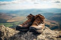 pair of hiking boots on a cliff edge overlooking mountains