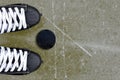 Pair of hockey skates with puck on a ice rink. Royalty Free Stock Photo