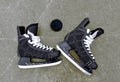 Pair of hockey skates with puck on a ice rink. Royalty Free Stock Photo