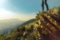 Pair of human feet stands on top of mountain against background of sunny valley