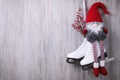 Pair of ice skates with Christmas gnome and decorative branches hanging on wooden wall, space for text Royalty Free Stock Photo