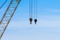 Pair of industrial crane hoists on cables near truss. Royalty Free Stock Photo