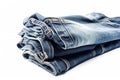 a pair of jeans folded on top of each other on a white surface with a reflection of the jeans on the bottom of the pair Royalty Free Stock Photo