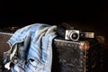 Pair of jeans and movie camera on suitcase Royalty Free Stock Photo