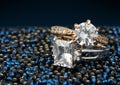Pair of jewelry rings with big diamonds on dark blue background