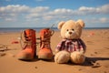 pair of kids boots and a soft toy on a sandy beach Royalty Free Stock Photo