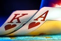 A pair of king and ace of hearts suit playing cards on a blue background of a gaming table in a casino. Close up of Royalty Free Stock Photo