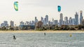 Pair of kitesurfers trains in Port Phillip Bay, with the skyline of Melbourne, Australia in the background