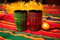 a pair of kwanzaa unity cups on a colorful african cloth