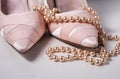 Pair of ladies pink high heels with long strand of white pearls Royalty Free Stock Photo