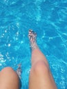 Pair of legs in a blue swimming pool