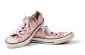 Pair of light pink worn textile sneakers with laces isolated on a white background