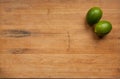 Pair of limes on a worn cutting board