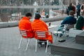 A pair of lovers covered with orange blankets sit on bench near summer cafe in Gorky Park.