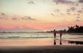 A pair of lovers running along the beach at sunset Royalty Free Stock Photo