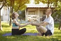 Pair of lovers sit on a rug for yoga and hold hands. Morning in