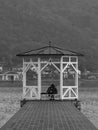 Pair of lovers under a gazebo on the pier of a lake