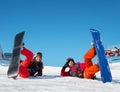 Pair lying with their snowboards on ski slope and looking at the camera with smile Royalty Free Stock Photo