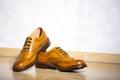 Pair of Male Full Brogued Tan Oxford Shoes. Placed Together on Tiles Floor Royalty Free Stock Photo