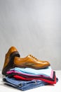 Pair of Male Full Brogued Tan Oxford Shoes Placed on Top of Heap Of Clothing